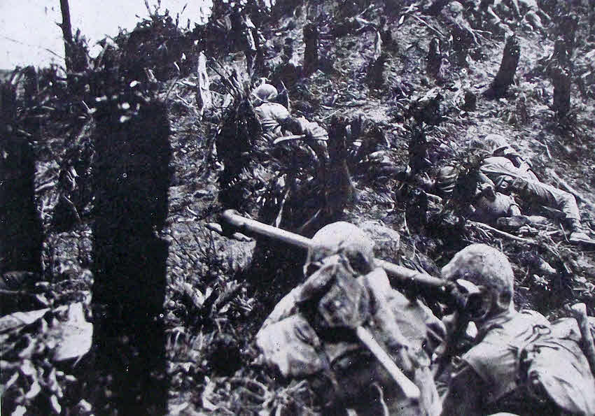 Marines advance with bazooka up hillside, Okinawa 