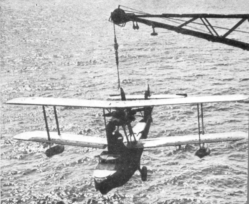 A Supermarine Walrus being hoisted back onto its ship at the end of a mission