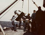 Crew of USS Miami (CL-89) hoist in paravane, 26 March 1945 