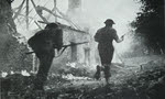 British troops passing burning Farm, Normandy 