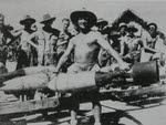 Warrant-Officer A. Warren carrying 250lb bomb, Burma 