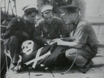 Crew of HMS Unsparing sowing victories onto flag 