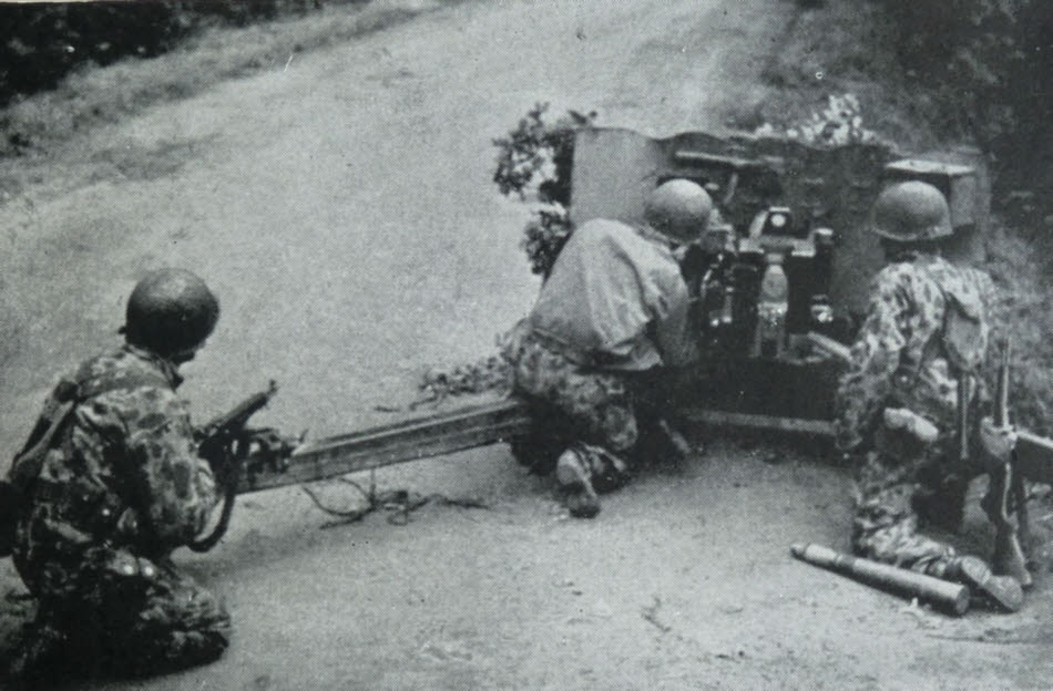 57mm M1 anti-tank gun on street, Normandy 