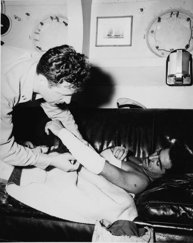 Treating wounded crewman from Argento on USS Buck (DD-420) 