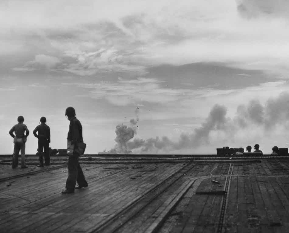 Crewmen on USS Kalinin Bay (CVE-68) watching explosions on USS St Lo (CVE-63) 