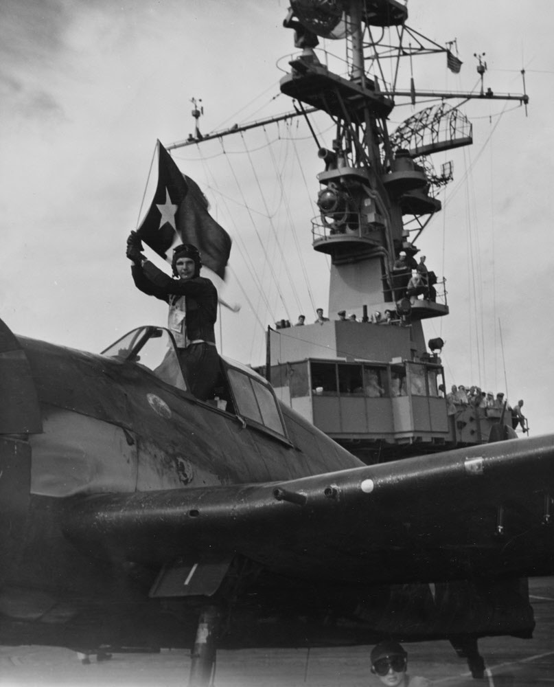 Lt James flies Texas Flag after landing on USS Wright (CVL-49) 
