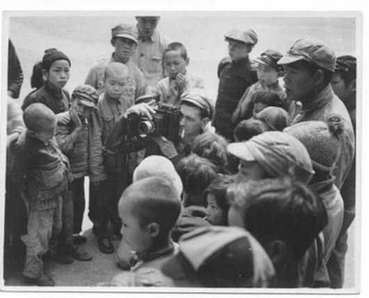 This picture shows Captain Harold C. James, USAAF, with a group of children at Kunming, where he was based with the 341st Bombardment Group.
