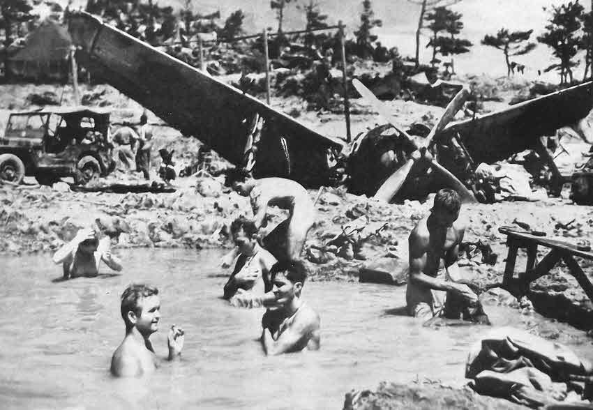 US Marines bath in bomb crater, Okinawa